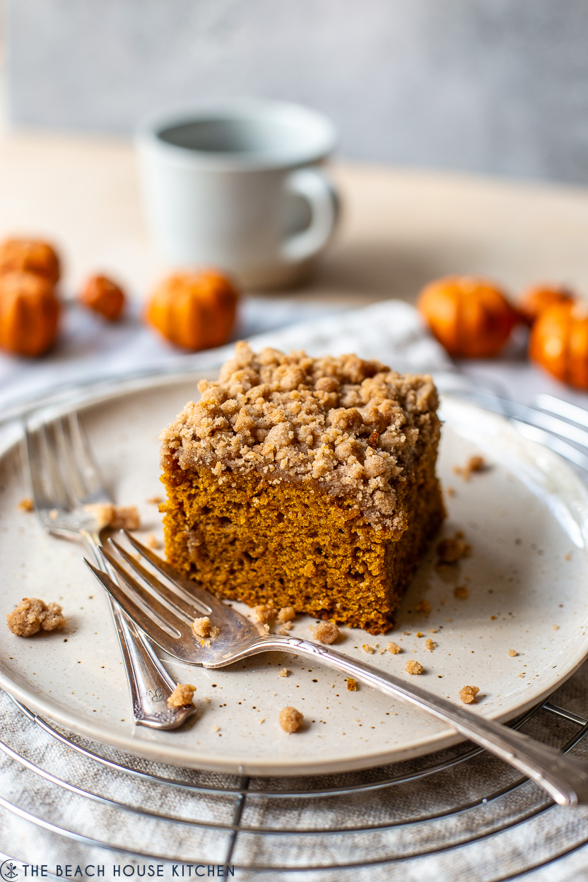 Slice of pumpkin crumb snack cake on a plate with two forks