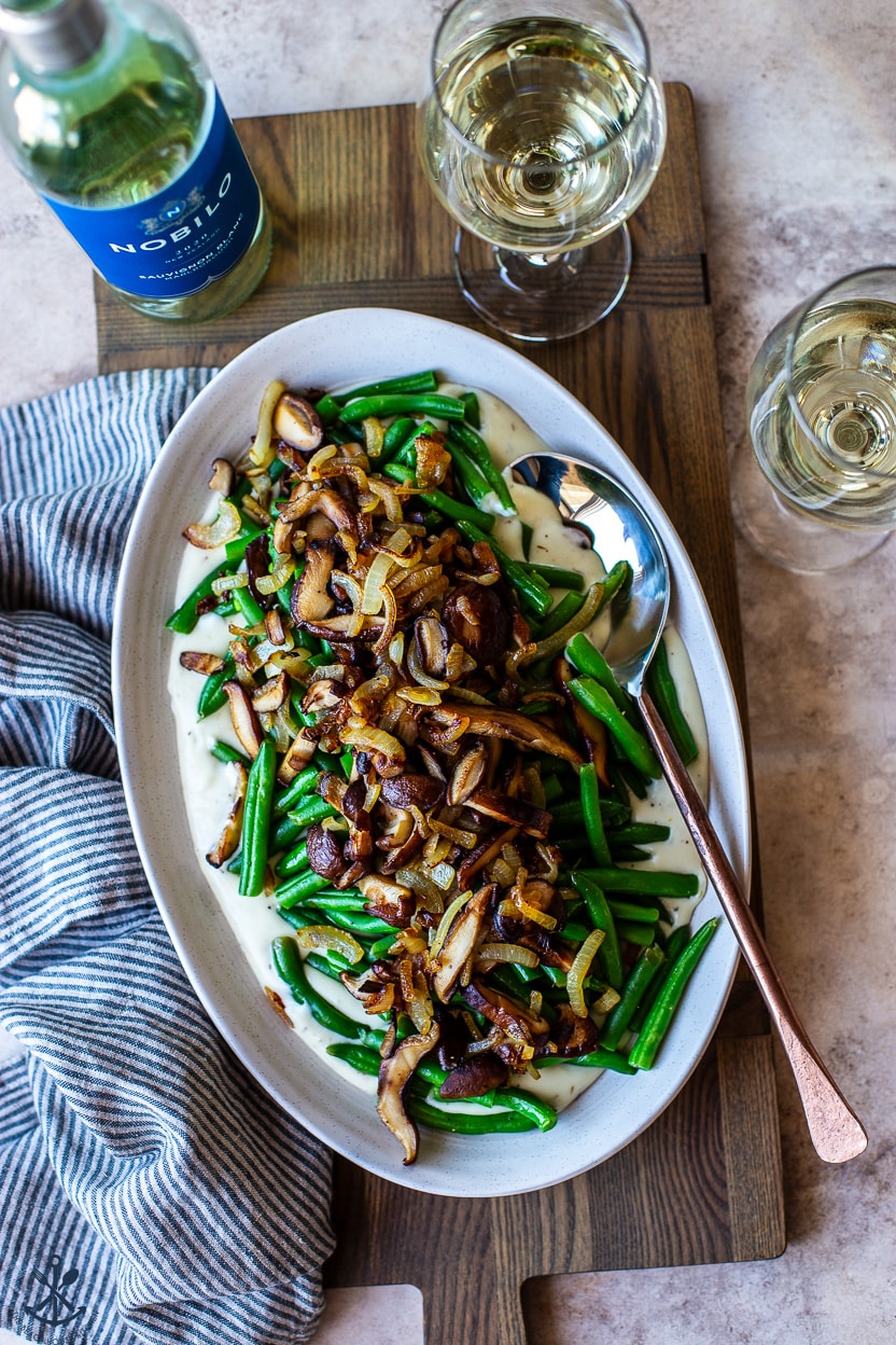 Overhead photo of a plate of green beans with mushrooms onions and mornay sauce