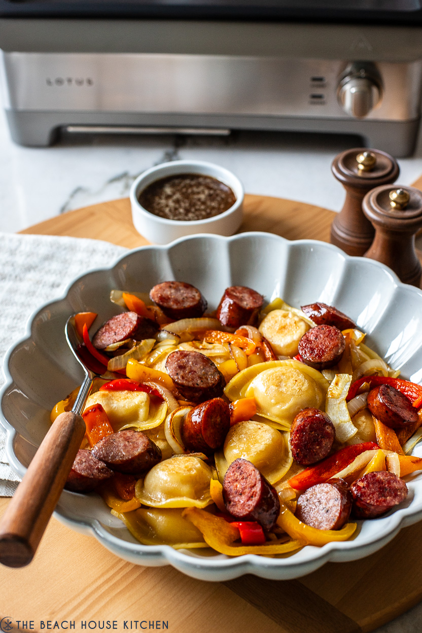 Picture of serving dish filled with Pierogies Kilebasa Peppers and Onions