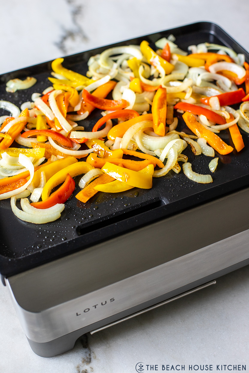 Photo of a griddle topped with cooked peppers and onions