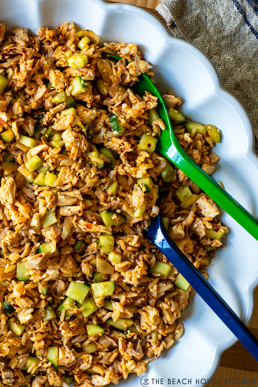 Super up close photo of a spicy chicken and rice salad in the white scalloped platter