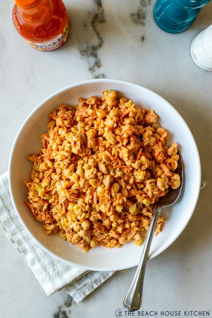 Up close overhead photo of a white bowl filled with buffalo chickpea salad
