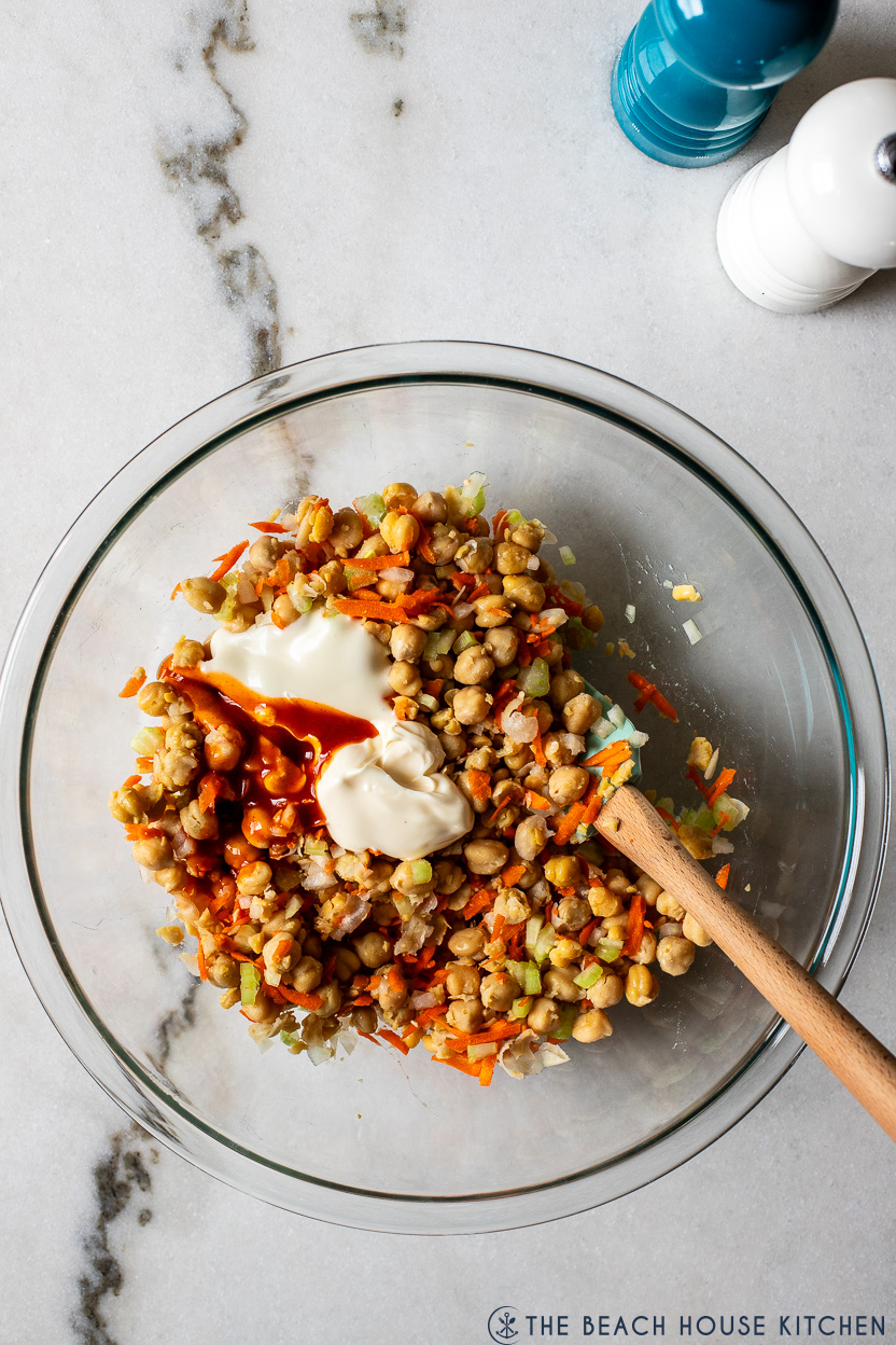 Overhead photo of a chickpea salad topped with mayo, ranch dressing and buffalo sauce