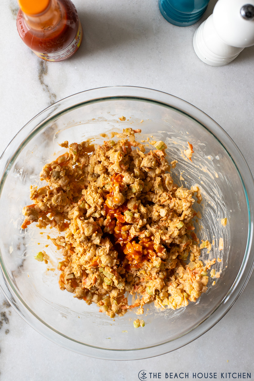 Overhead photo of a bowl of buffalo chickpea salad topped with extra buffalo sauce