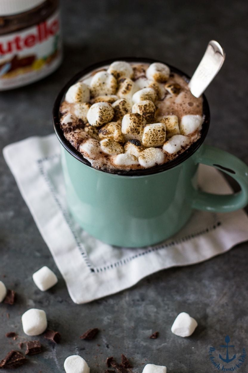A green mug filled with nutella hot cocoa topped with toasted mini marshmallows