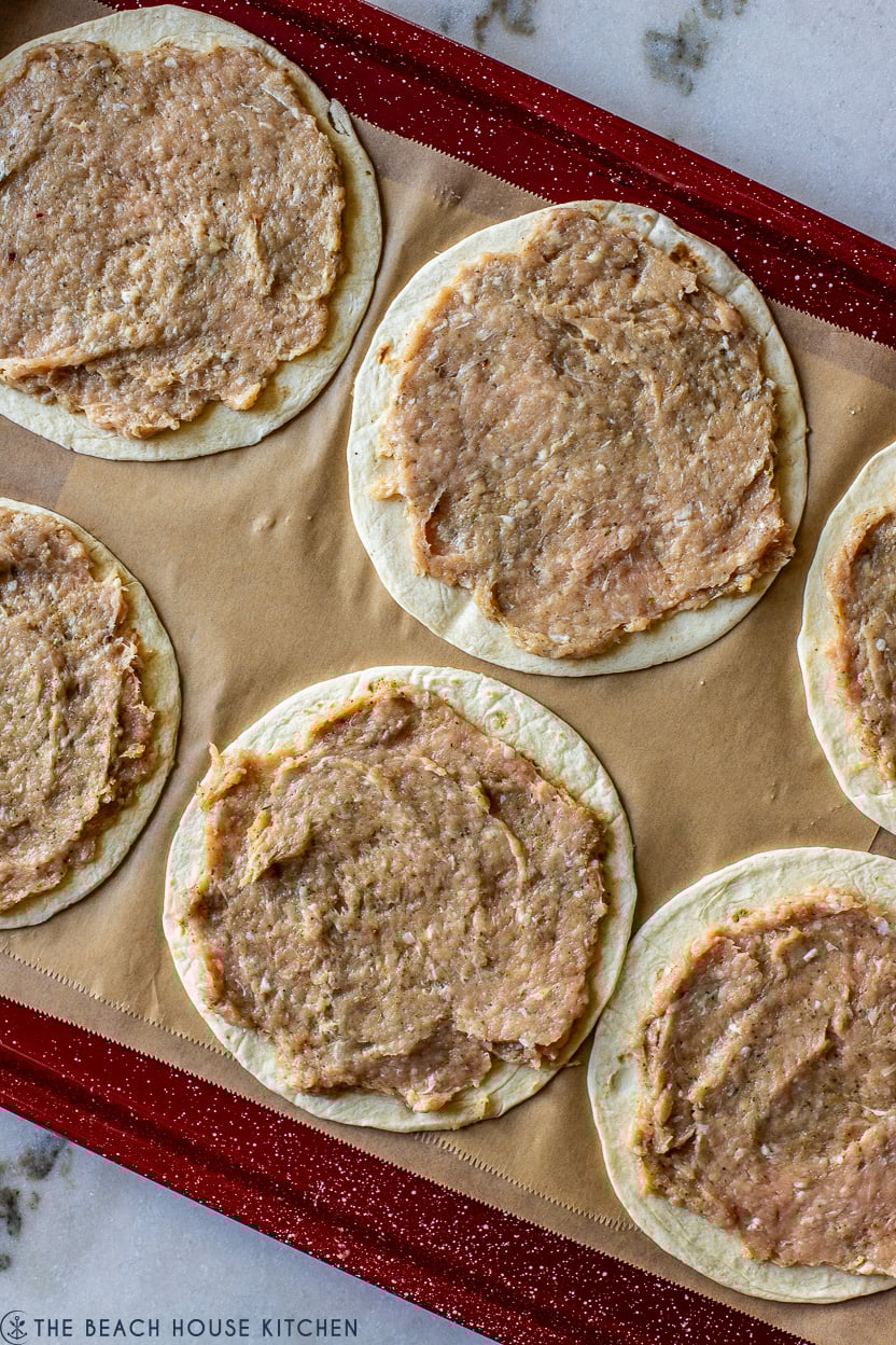 Overhead photo of ground chicken mixture on top of flour tortillas