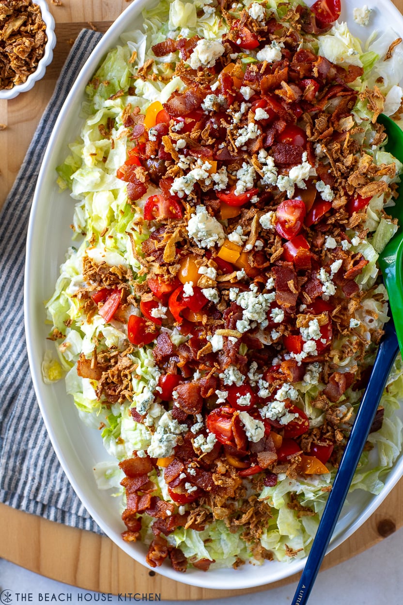 Up close overhead photo of a chopped wedge salad on a white oval platter
