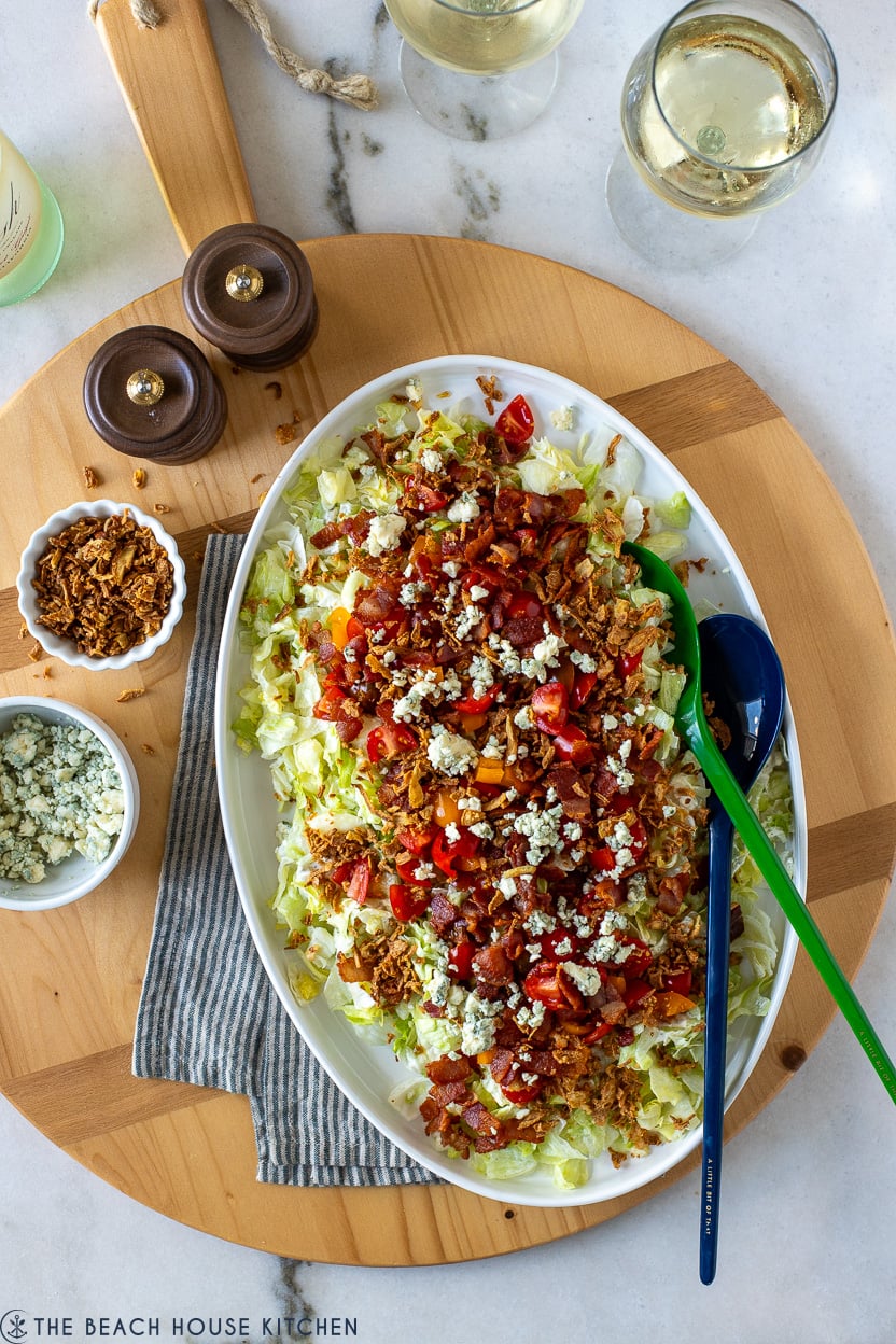 Overhead photo of a chopped wedge salad on a round wooden board