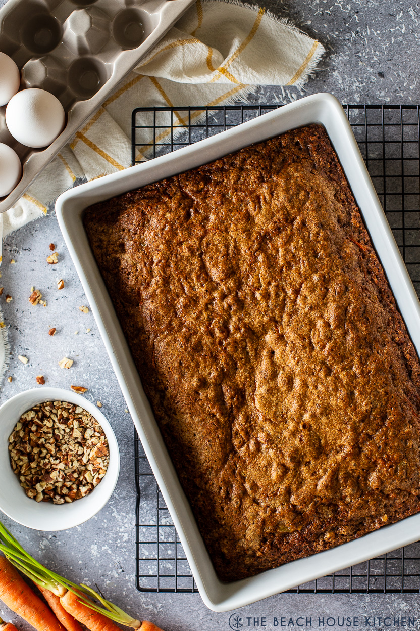 Overhead photo of a pre-frosted carrot cake in a white baking dish