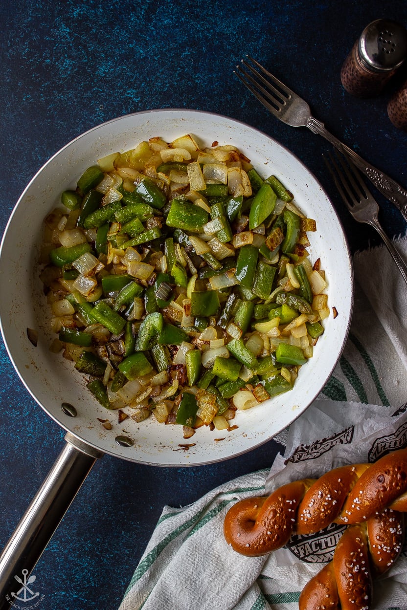 Overhead photo of a skilley filled with cooked green peppers and onions
