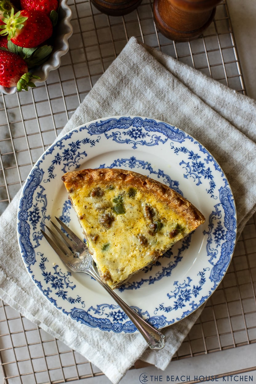 Up close overhead photo of a slice of quiche on a blue and white plate