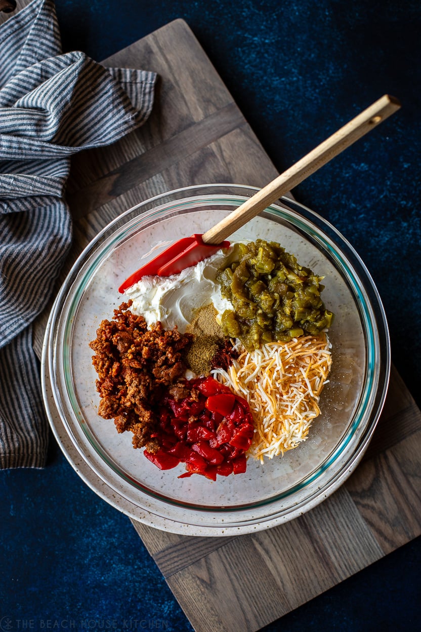 Overhead photo of a glass bowl of premixed ingredients for a cheesy Mexican Chorizo dip