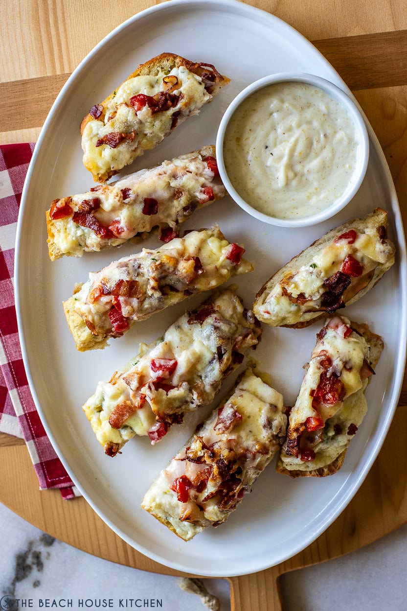 Overhead photo of a white oval platter topped with slices of Kentucky Hot Brown Garlic Bread