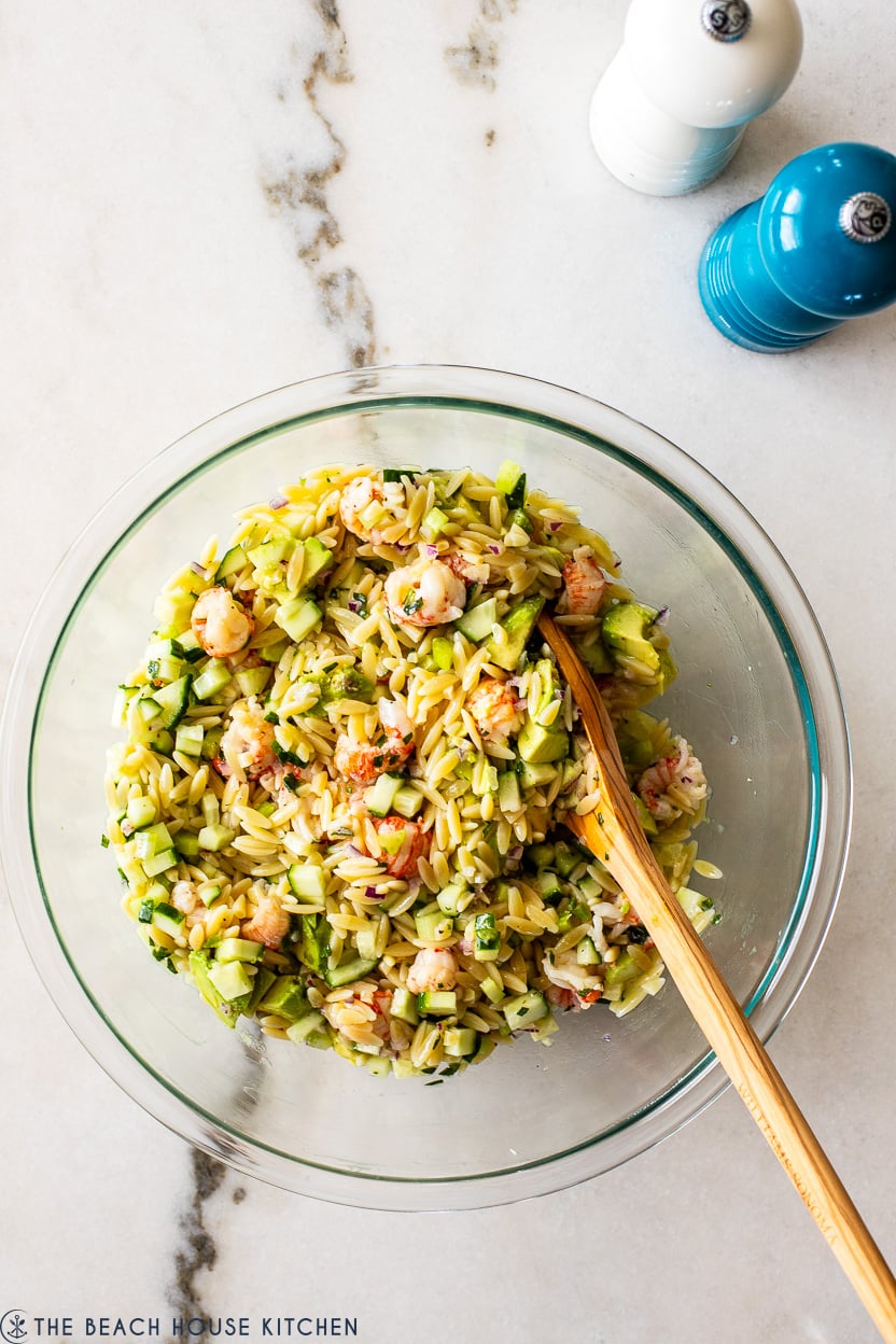 Overhead photo of a glass bowl filled with lobster orzo salad
