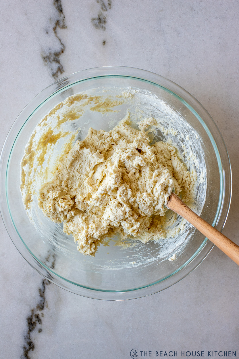 Up close overhead photo of a glass bowl of biscuit dough