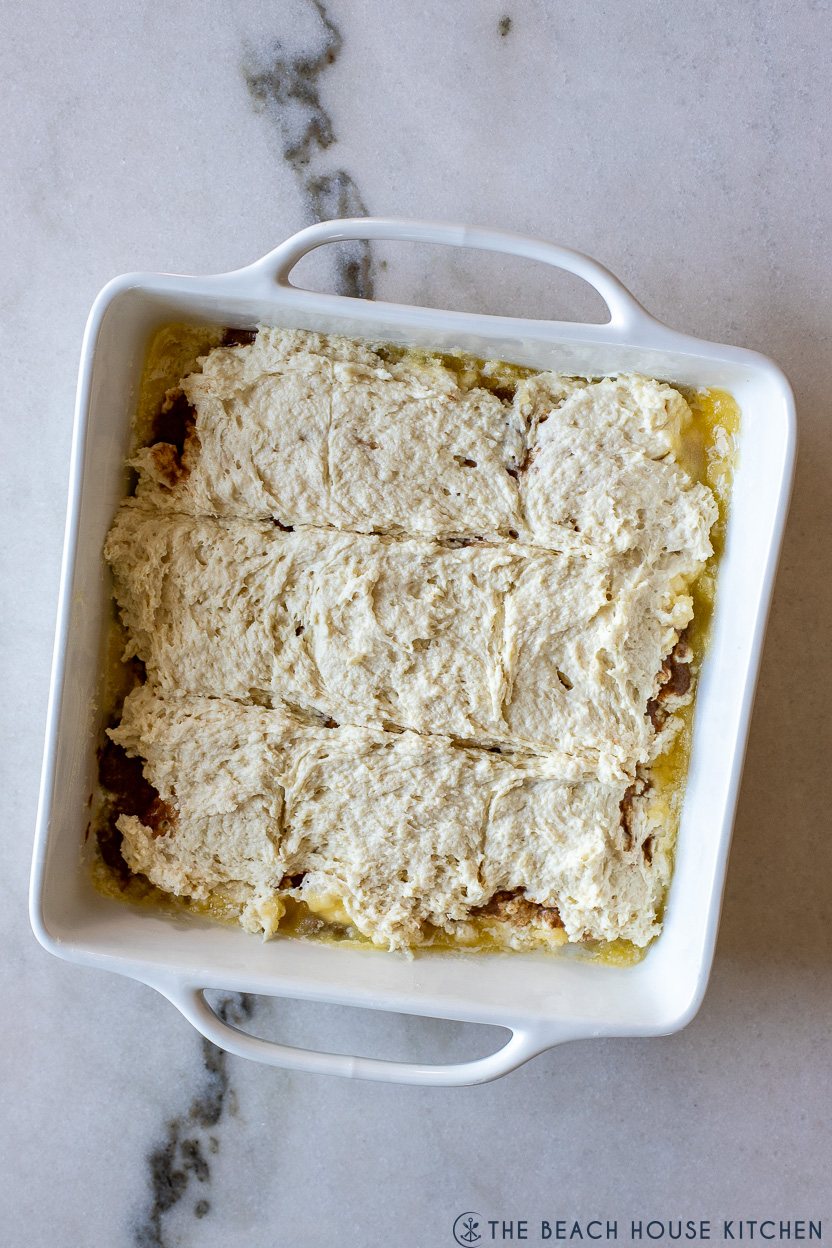 Overhead photo of a square white baking dish of pre-baked biscuits