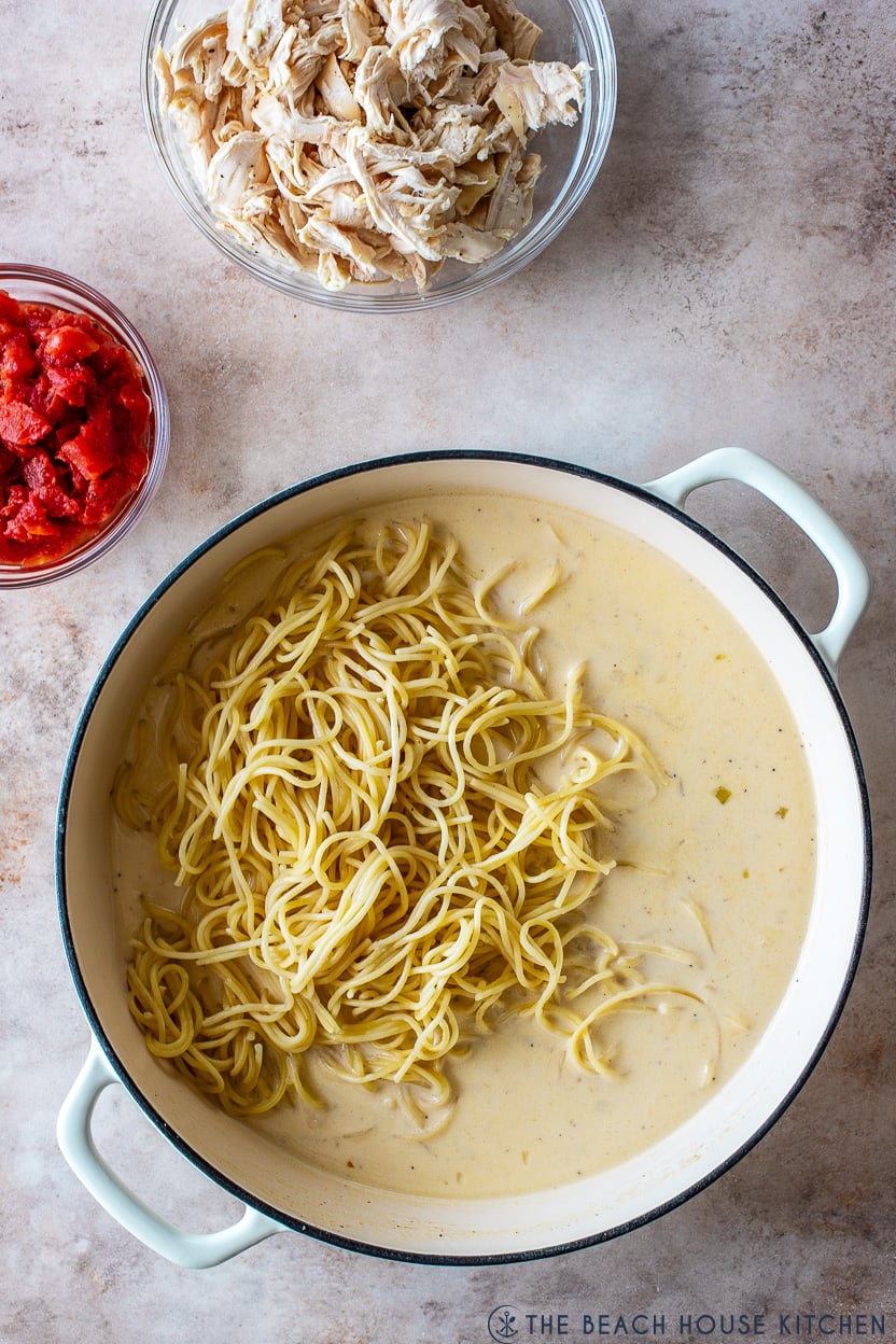Overhead photo of a round skillet filled with a creamy sauce topped with spaghetti
