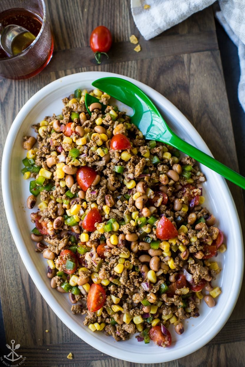 Up close overhead photo of a white oval platter of ground turkey cowboy caviar