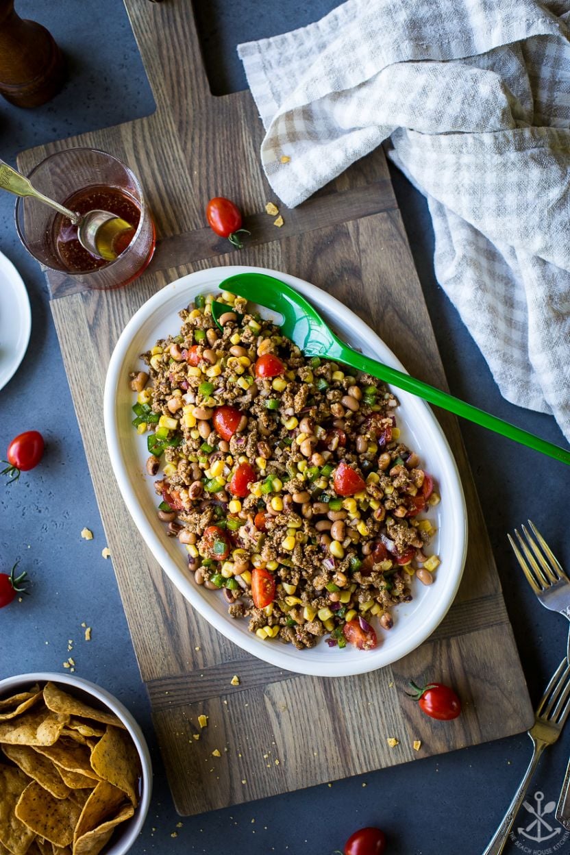 Overhead photo of an oval platter of ground turkey cowboy caviar on a wooden board