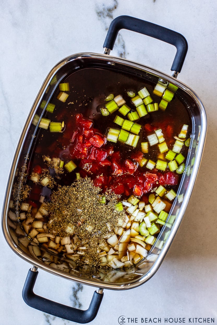 Overhead photo of a pot filled with broth, veggies and spices