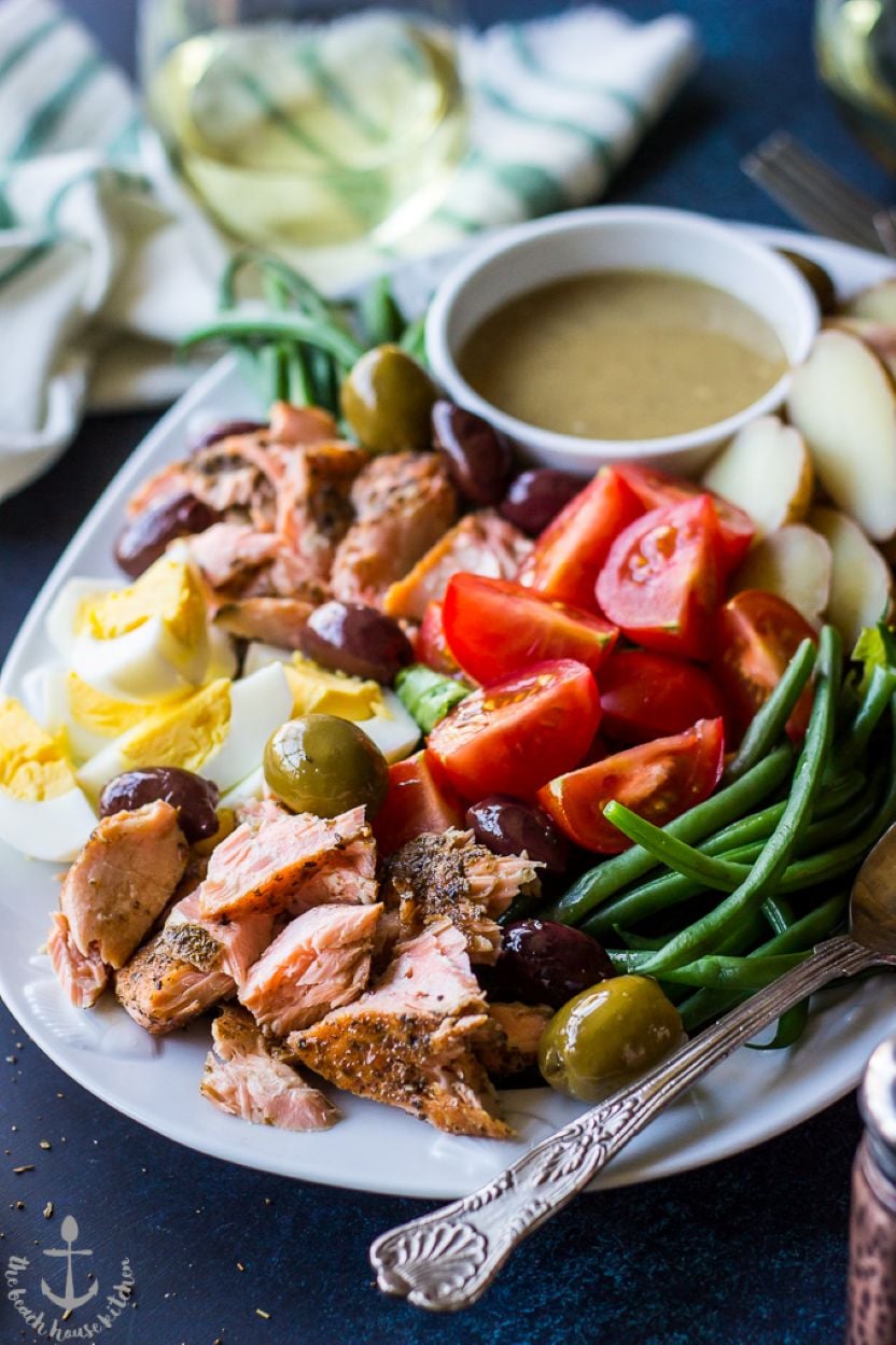 Up close photo of a Salmon Niçoise Salad with Dijon Vinaigrette on a white platter