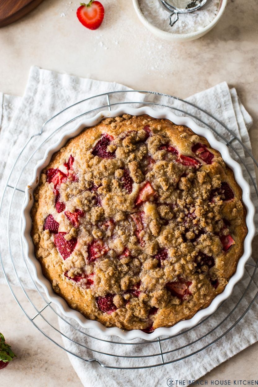 Up close photo of a strawberry buckle in a round white baking dish