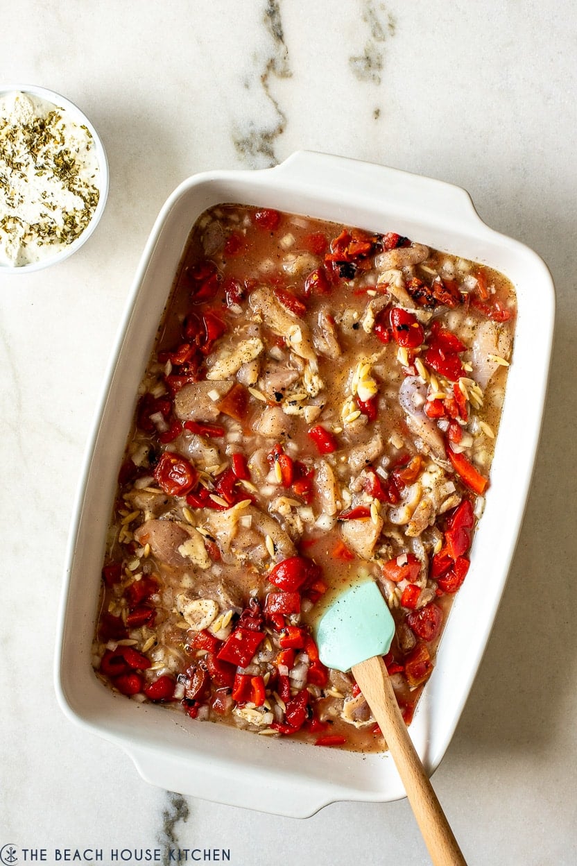 Overhead photo of a pre-baked cheesy garlic and herb chicken with orzo