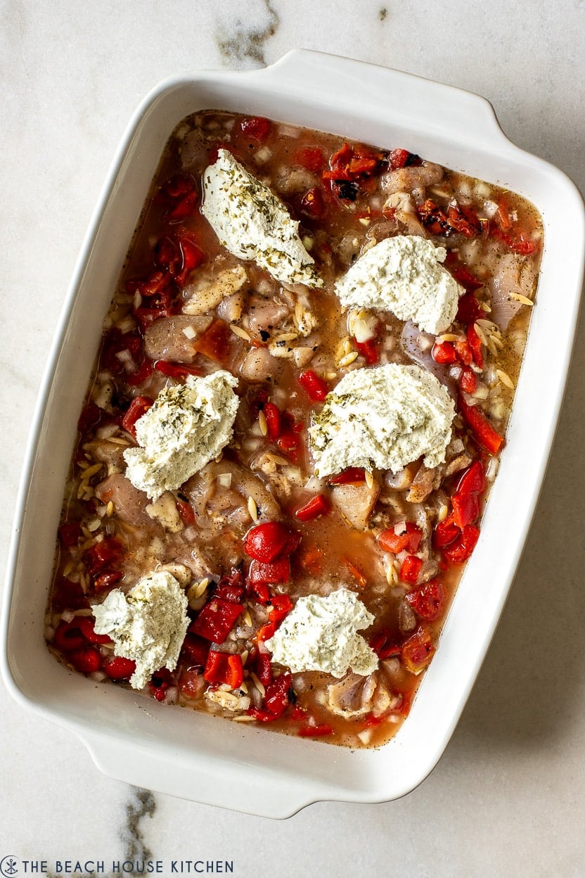 Overhead photo of a chicken and orzo mixture topped with alouette cheese dollops