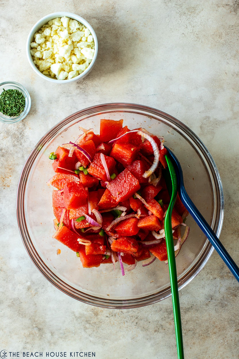 Overhead photo of a glass bowl filled with a spicy watermelon salad