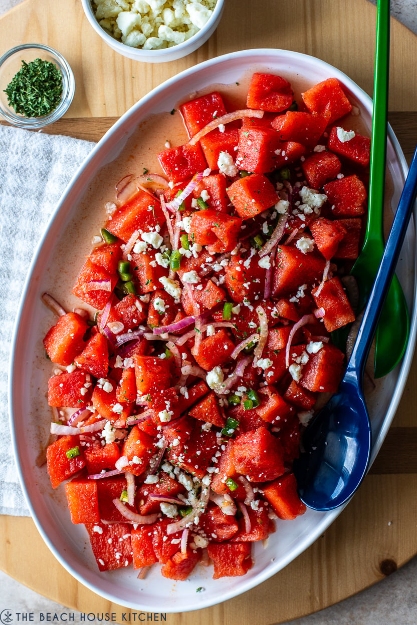 Very up close photo of a spicy watermelon salad topped with crumbled white cheese