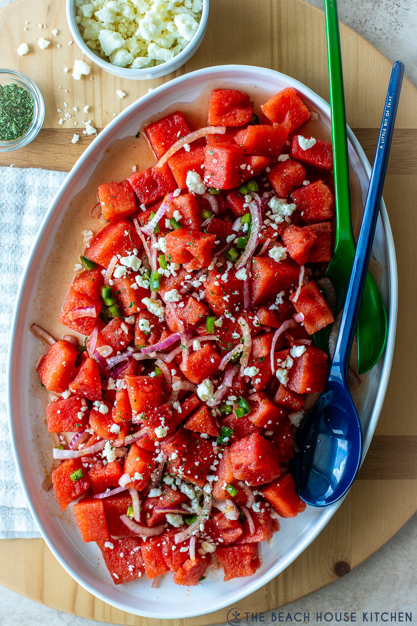 Up close overhead photo of a spicy watermelon salad on an oval white platter