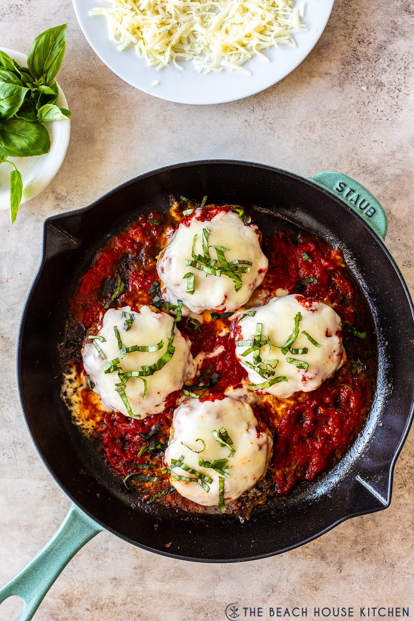 Overhead photo of a skillet of chicken pizza burgers