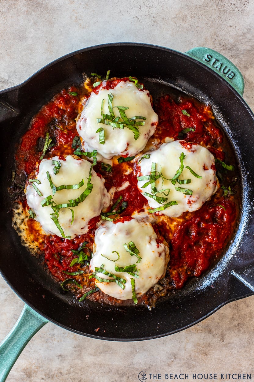 Up close overhead photo of a skillet of chicken pizza burgers