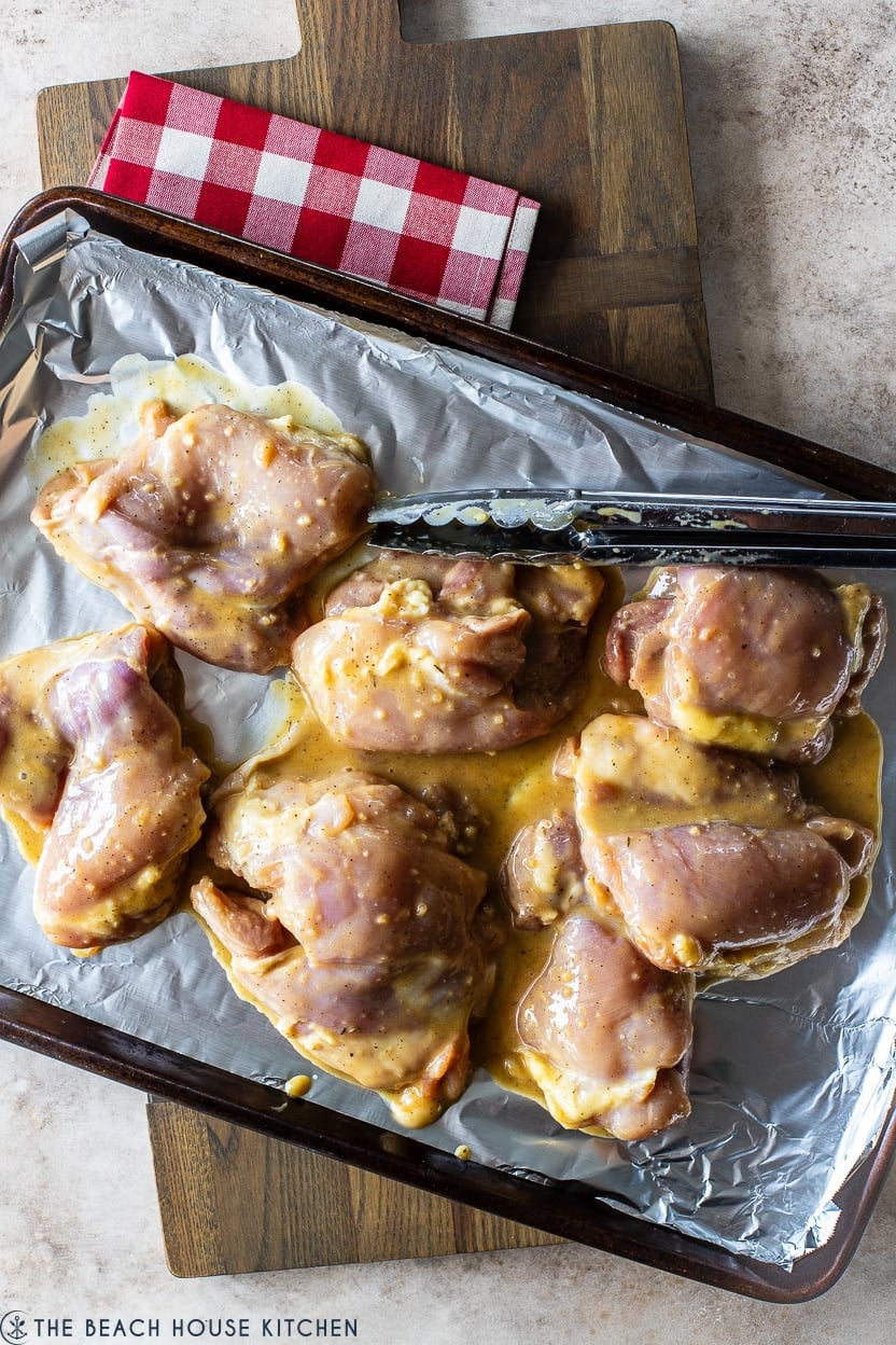 Overhead photo of a tray of marinated chicken pieces