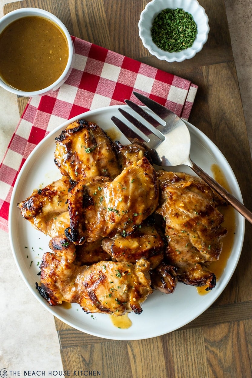 Up close overhead photo of a white plate of grilled honey dijon chicken thighs