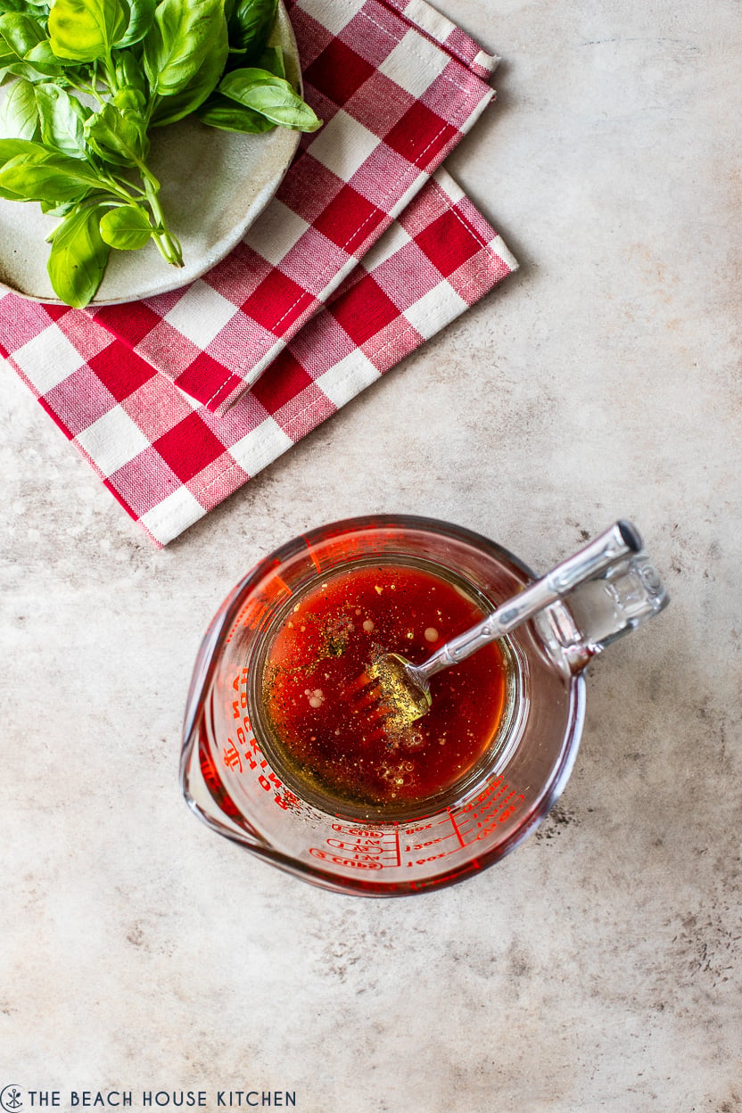 Overhead photo of vinaigrette dressing in a measuring cup with a fork