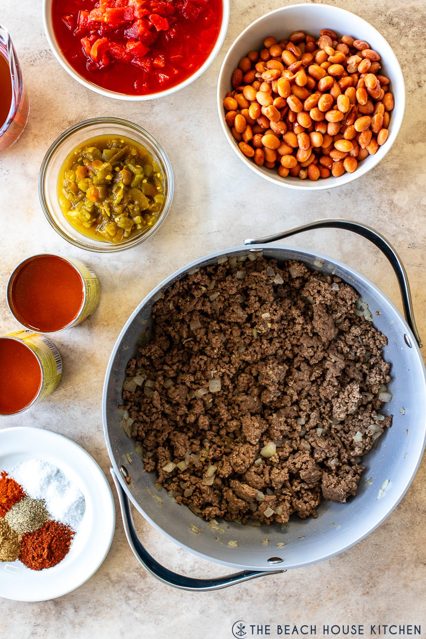 Overhead photo of a pot of cooked ground beef and other ingredients for beef enchilada chili