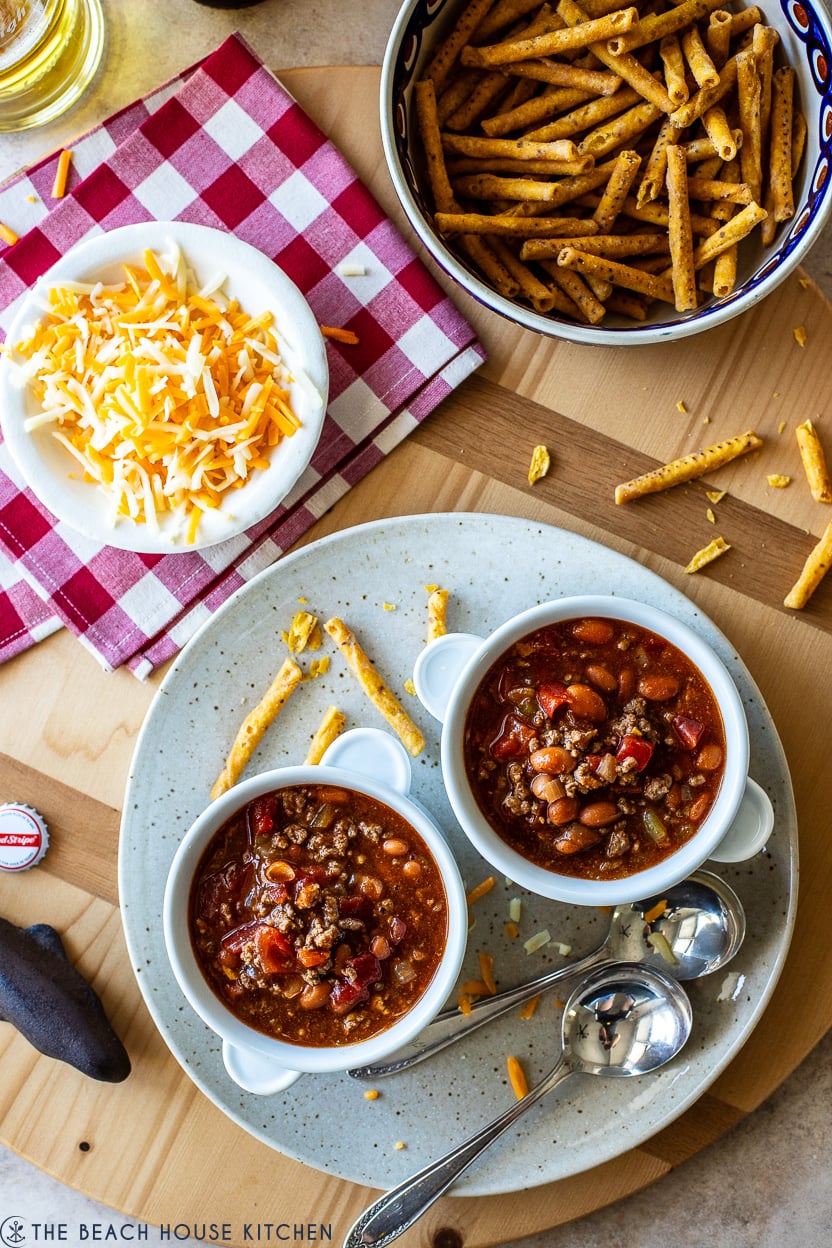 Overhead photo of a plate with two bowls of beef enchilada chili and two spoons
