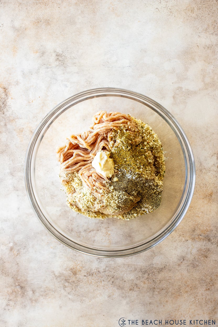 Overhead photo of a bowl filled with ground chicken bread crumbs, mayo and spices