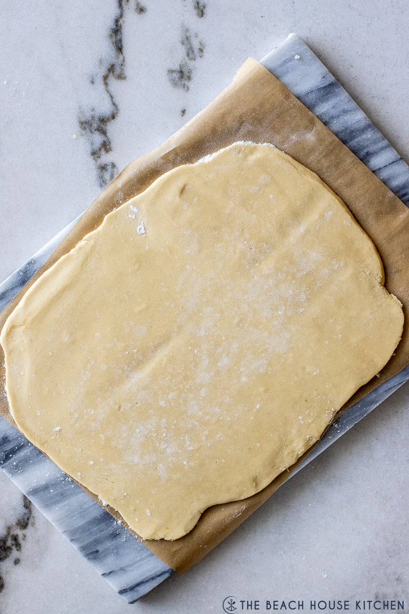 Overhead photo of a rectangular piece of cookie dough on a marble board