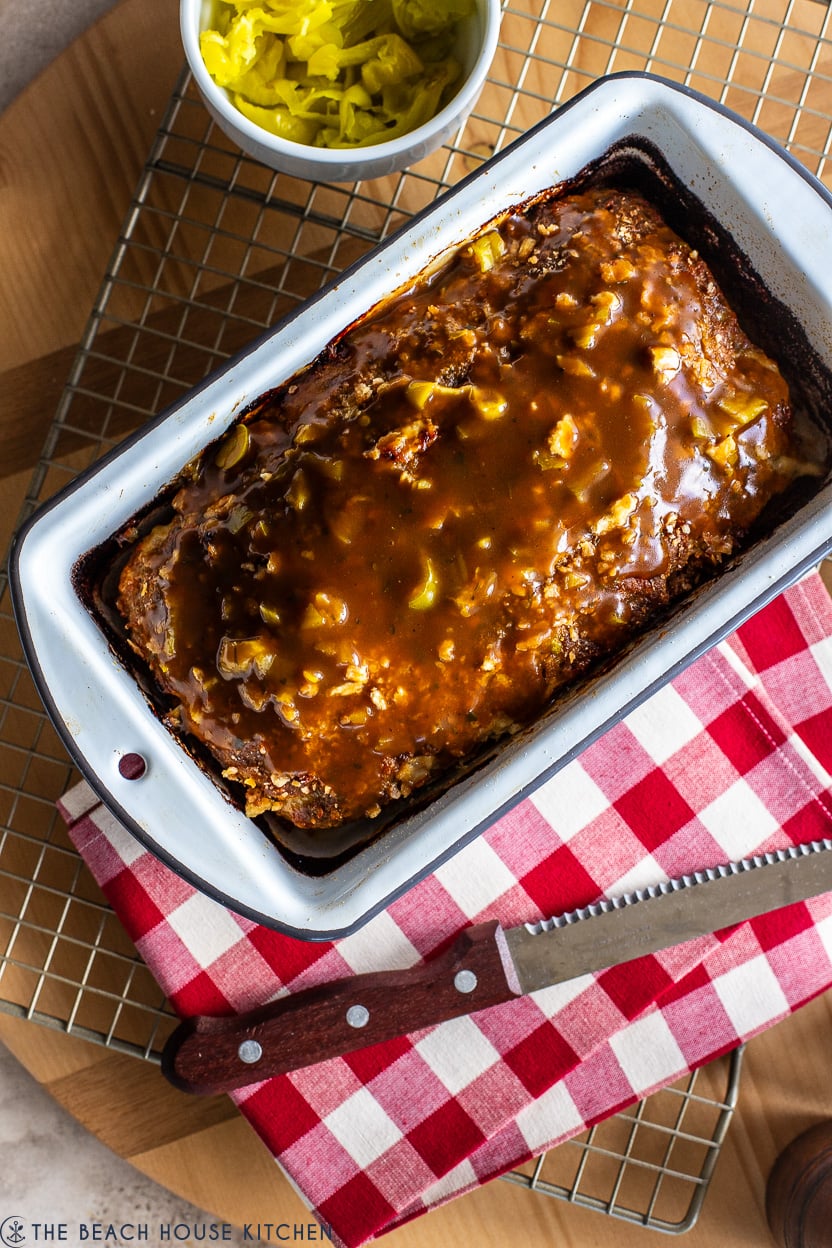 Up close overhead photo of a Mississippi Meatloaf on a wire rack with a red and white check napkin.