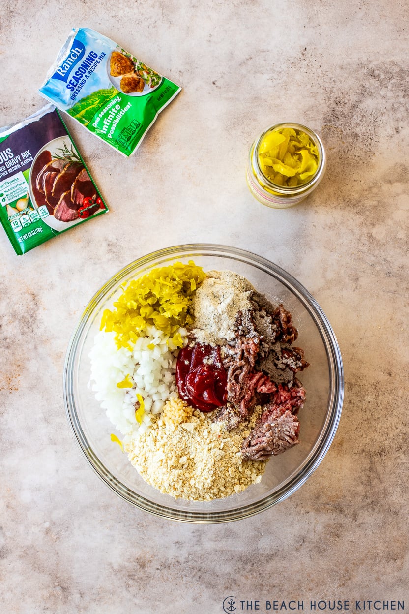 Overhead photo of a glass bowl filled with ingredients for a meatloaf