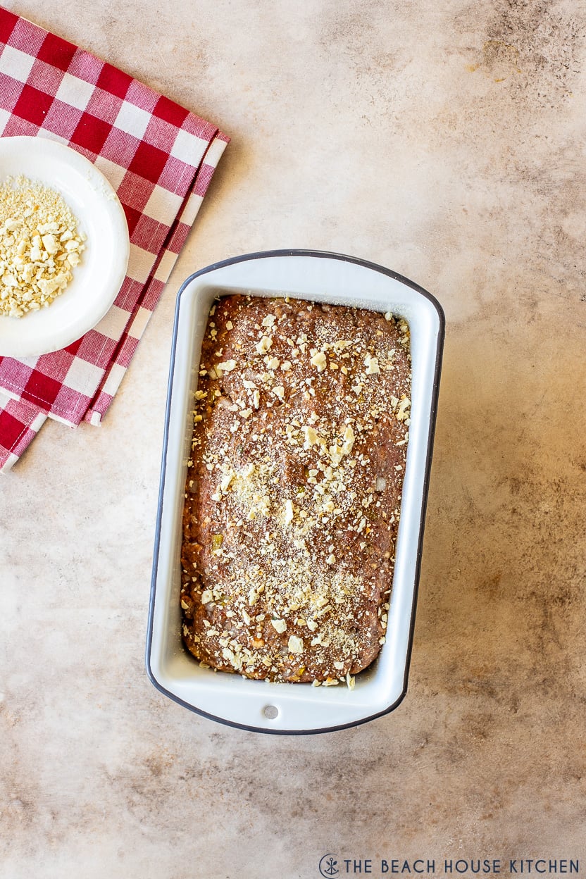 Overhead photo of a pre-baked meatloaf topped with cracker crumbs