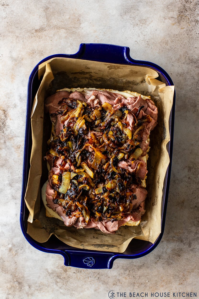 Overhead photo of roast beef sliders topped with caramelized onions