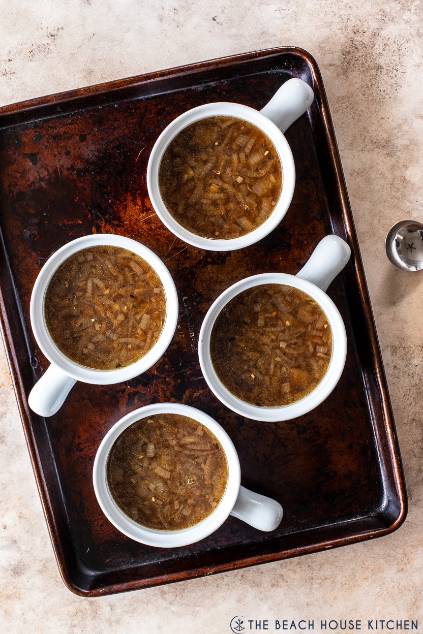 Overhead photo of four cracks of French onion soup on a baking sheet