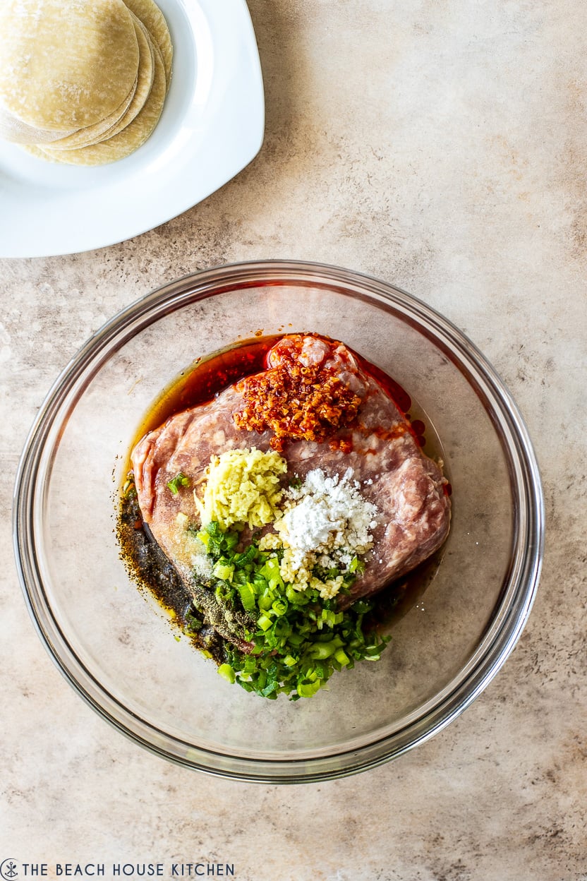 Overhead photo of glass bowl filled with pork dumpling filling